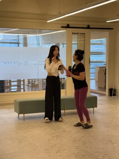 강사가 그룹수업 중 회원에게 기구 사용법을 설명하는 장면