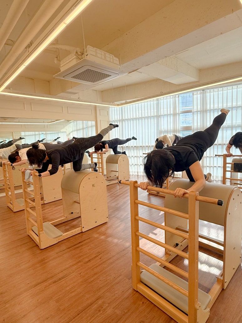 회원들이 바렐 기구를 짚고 다리 들기 동작을 진행하는 그룹수업